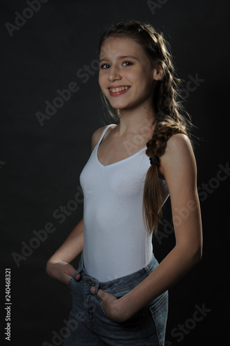 Beautiful teenager girl. Studio portrait. Dark background