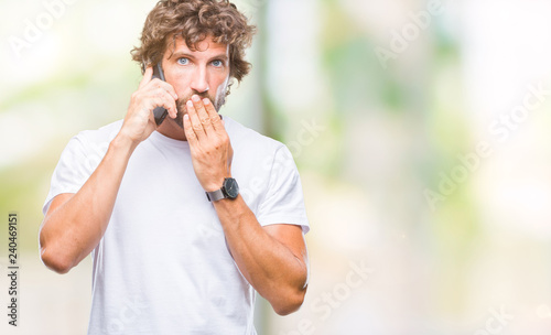 Handsome hispanic man model talking on smartphone over isolated background cover mouth with hand shocked with shame for mistake, expression of fear, scared in silence, secret concept
