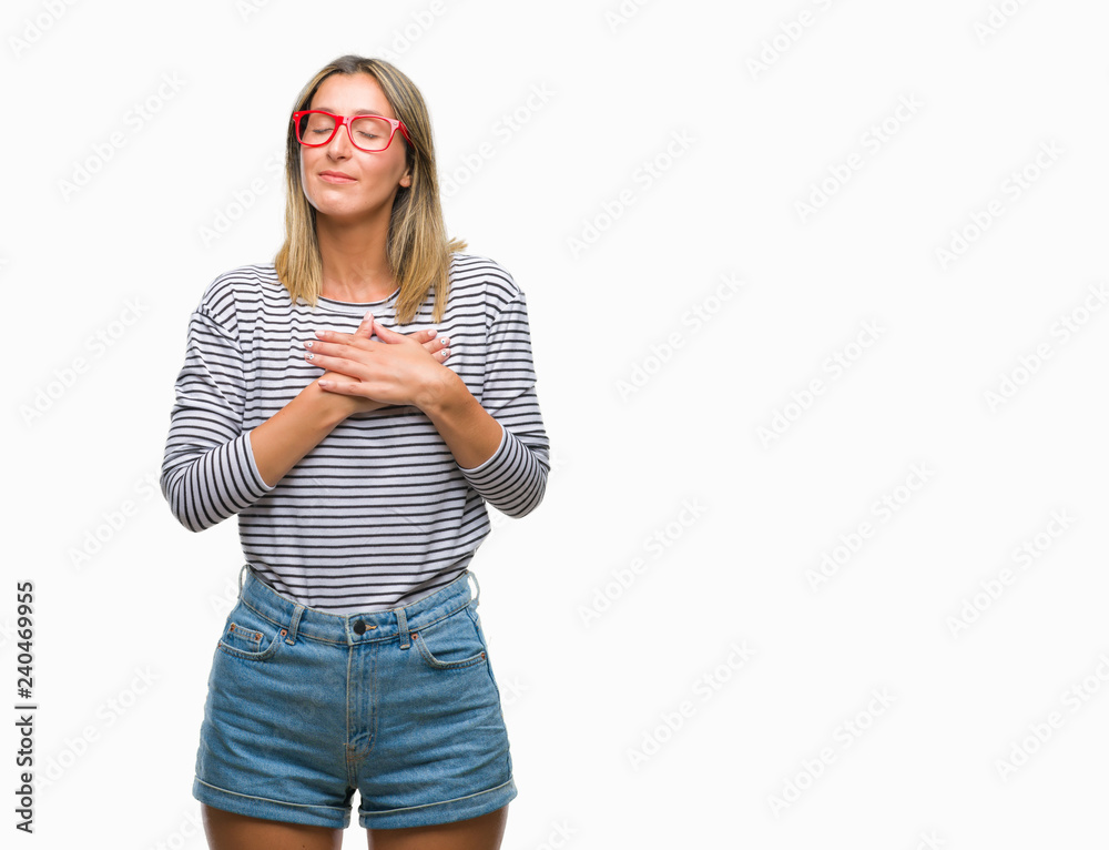 Young beautiful woman wearing glasses over isolated background smiling with hands on chest with closed eyes and grateful gesture on face. Health concept. Young beautiful woman wearing glasses over isolated background smiling with hands on chest with closed eyes and grateful gesture on face. Health concept.