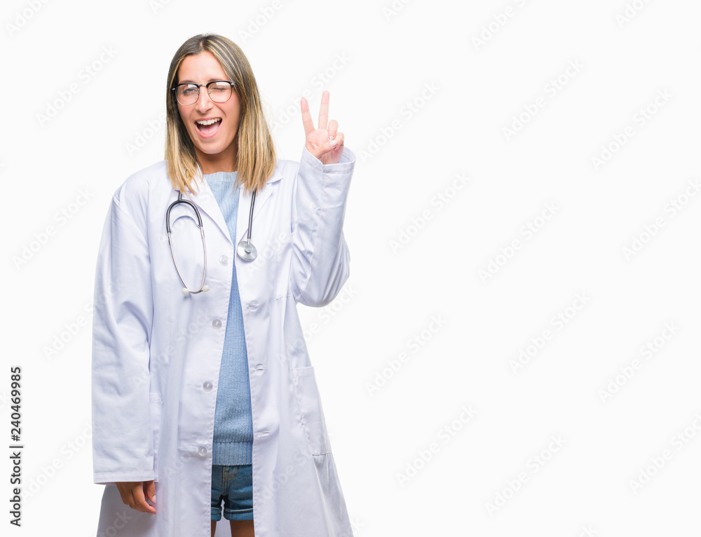 Young beautiful doctor woman headphones over isolated background smiling with happy face winking at the camera doing victory sign. Number two. Young beautiful doctor woman headphones over isolated background smiling with happy face winking at the camera doing victory sign. Number two.