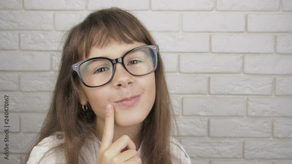 A child with glasses thinks. A cute little girl thinks. A child with glasses thinks. A cute little girl thinks.
