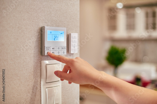 Woman programming temperature inside home photo