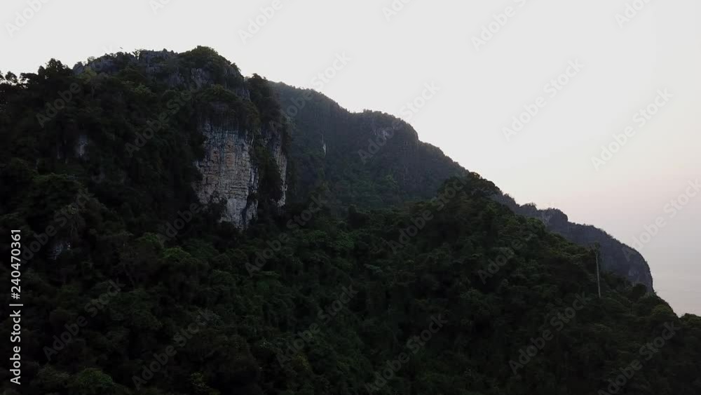 4K aerial view of a rain forest and a huge rocky hill of limestone 4K aerial view of a rain forest and a huge rocky hill of limestone