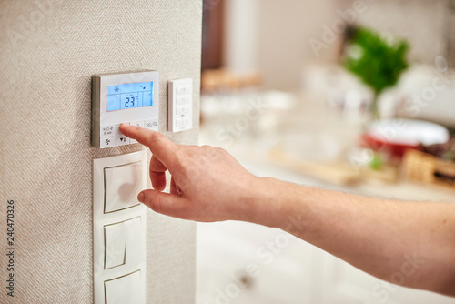 Digital Thermostat and male hand photo