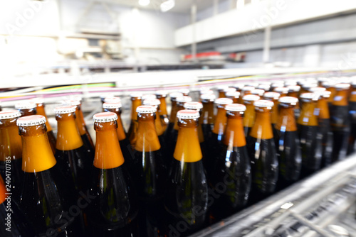 Filling beer bottles on the conveyor belt in a brewery in industrial plant // Bierflaschen in der Abfüllung auf dem Fliessband in einer Brauerei 