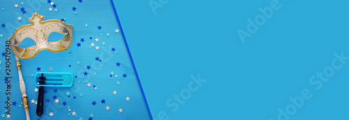 Purim celebration concept (jewish carnival holiday) over blue wooden background. Top view.