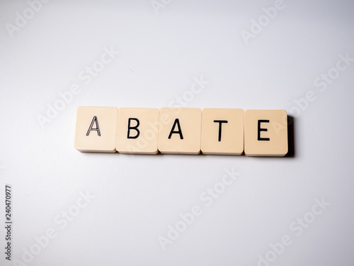 Abate word made with blocks on white table. Top view