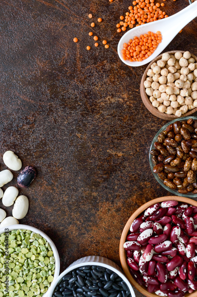 Healthy food, dieting, nutrition concept, vegan protein source. Assortment of colorful raw legumes: lentils, green peas, beans, chickpeas in bowls. Background. Free space.