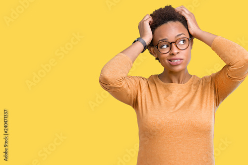 Young beautiful african american woman wearing glasses over isolated background confuse and wonder about question. Uncertain with doubt, thinking with hand on head. Pensive concept.
