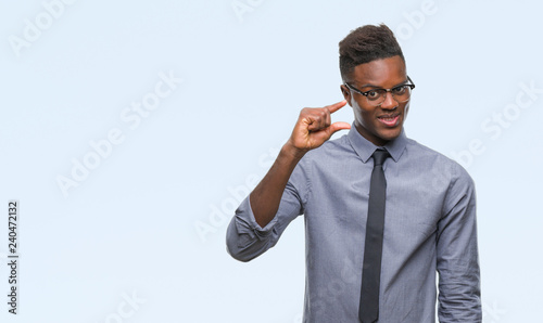 Young african american business man over isolated background smiling and confident gesturing with hand doing size sign with fingers while looking and the camera. Measure concept.