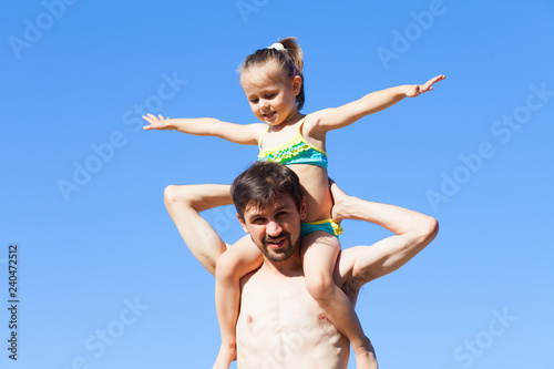 Girl is sitting on her father's shoulders