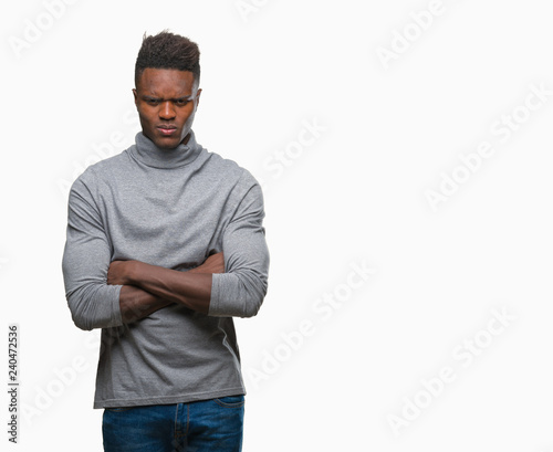 Young african american man over isolated background skeptic and nervous, disapproving expression on face with crossed arms. Negative person.