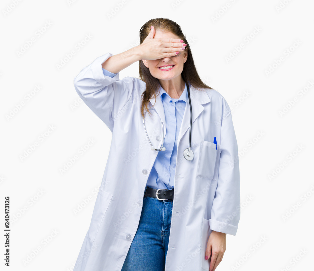 Middle age mature doctor woman wearing medical coat over isolated background smiling and laughing with hand on face covering eyes for surprise. Blind concept. Middle age mature doctor woman wearing medical coat over isolated background smiling and laughing with hand on face covering eyes for surprise. Blind concept.