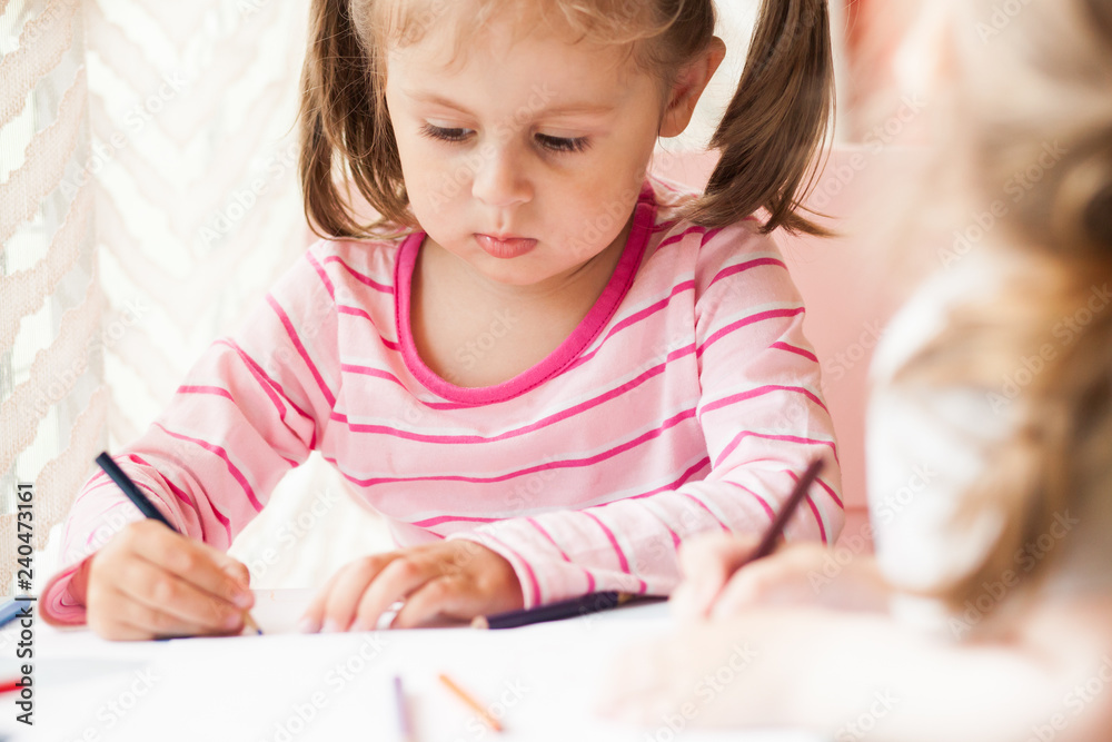 The girl draws in colored pencils The girl draws in colored pencils