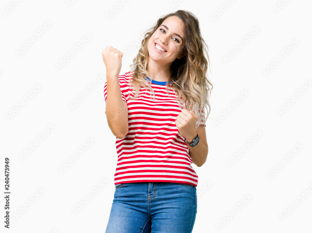 Beautiful young blonde woman over isolated background very happy and excited doing winner gesture with arms raised, smiling and screaming for success. Celebration concept. Beautiful young blonde woman over isolated background very happy and excited doing winner gesture with arms raised, smiling and screaming for success. Celebration concept.