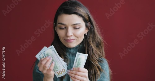 Atractive beautiful brunette woman count money and think about how to spend them.