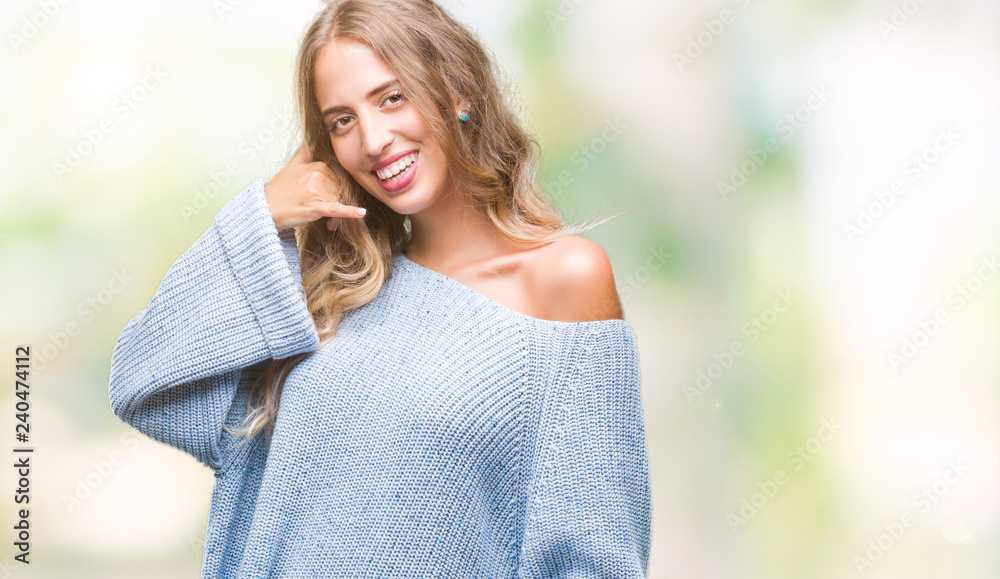 Beautiful young blonde woman wearing winter sweater over isolated background smiling doing phone gesture with hand and fingers like talking on the telephone. Communicating concepts.