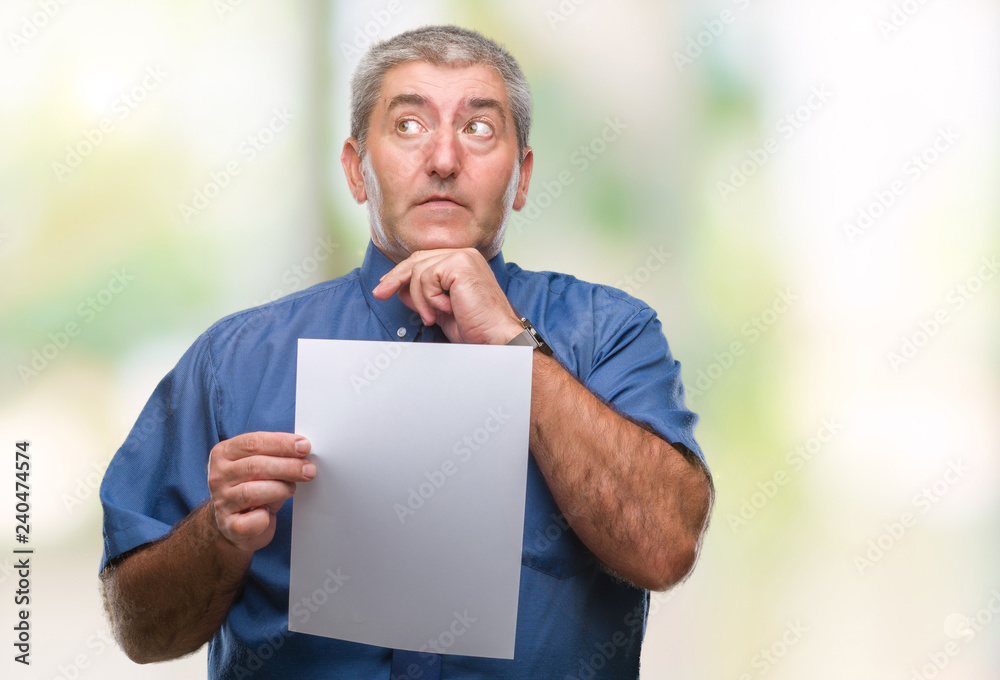 Handsome senior man holding blank sheet paper over isolated background serious face thinking about question, very confused idea Handsome senior man holding blank sheet paper over isolated background serious face thinking about question, very confused idea