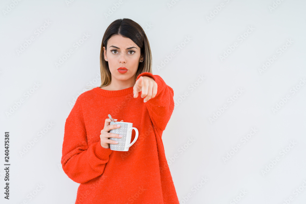 Young woman drinking cup of coffee over isolated background pointing with finger to the camera and to you, hand sign, positive and confident gesture from the front Young woman drinking cup of coffee over isolated background pointing with finger to the camera and to you, hand sign, positive and confident gesture from the front