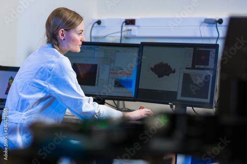 Female researcher carrying out research in a physics/chemistry lab (color toned image; shallow DOF) photo