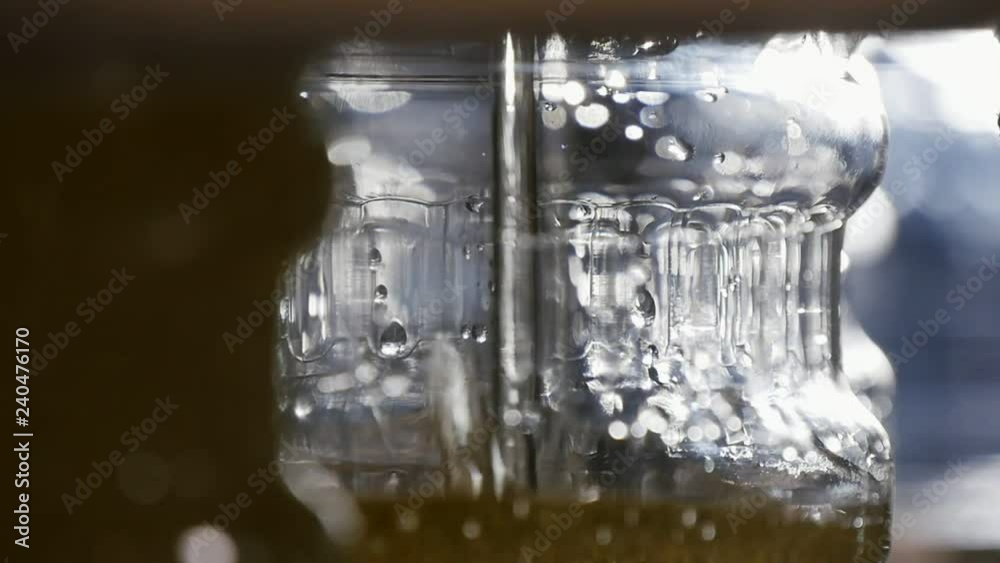 Sunflower oil streaming into see-through plastic bottles on a plant in slow motion Sunflower oil streaming into see-through plastic bottles on a plant in slow motion