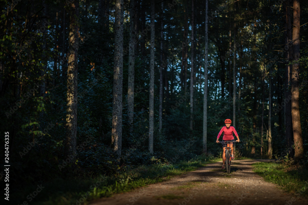 Pretty, young woman biking on a mountain bike enjoying healthy active lifestyle outdoors in summer (shallow DOF) Pretty, young woman biking on a mountain bike enjoying healthy active lifestyle outdoors in summer (shallow DOF)