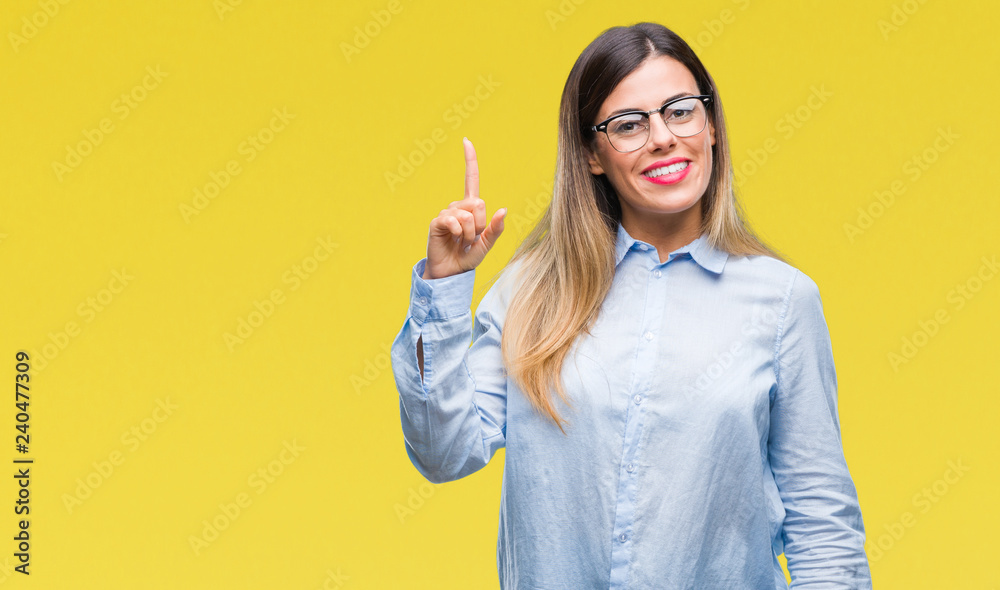 Young beautiful business woman wearing glasses over isolated background pointing finger up with successful idea. Exited and happy. Number one. Young beautiful business woman wearing glasses over isolated background pointing finger up with successful idea. Exited and happy. Number one.