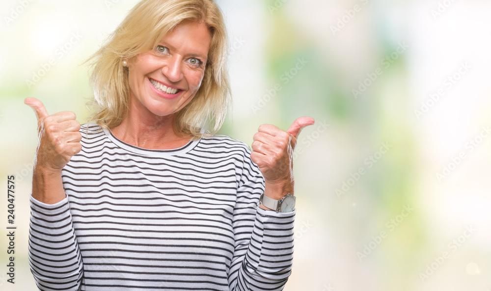 Middle age blonde woman over isolated background success sign doing positive gesture with hand, thumbs up smiling and happy. Looking at the camera with cheerful expression, winner gesture. Middle age blonde woman over isolated background success sign doing positive gesture with hand, thumbs up smiling and happy. Looking at the camera with cheerful expression, winner gesture.