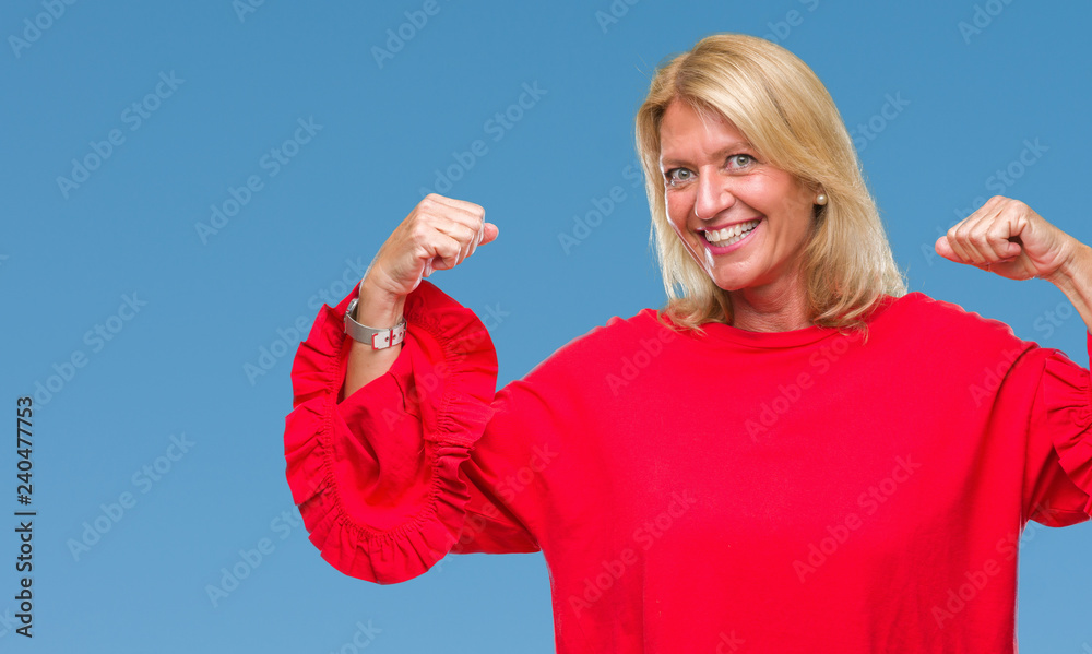 Middle age blonde woman over isolated background showing arms muscles smiling proud. Fitness concept. Middle age blonde woman over isolated background showing arms muscles smiling proud. Fitness concept.