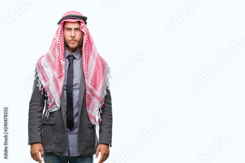 Young handsome arabian man with long hair wearing keffiyeh over isolated background skeptic and nervous, frowning upset because of problem. Negative person.