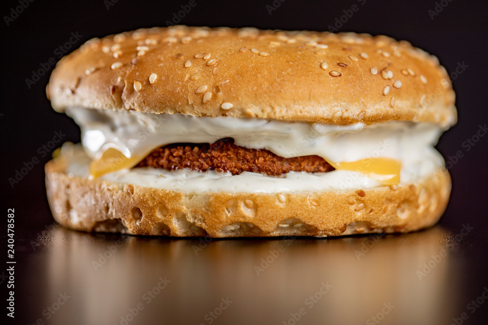 Fish burger close up on isolated black background Fish burger close up on isolated black background