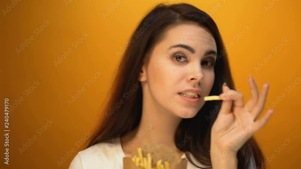 Happy girl dancing with french fries, favorite fast food, satisfied customer Happy girl dancing with french fries, favorite fast food, satisfied customer