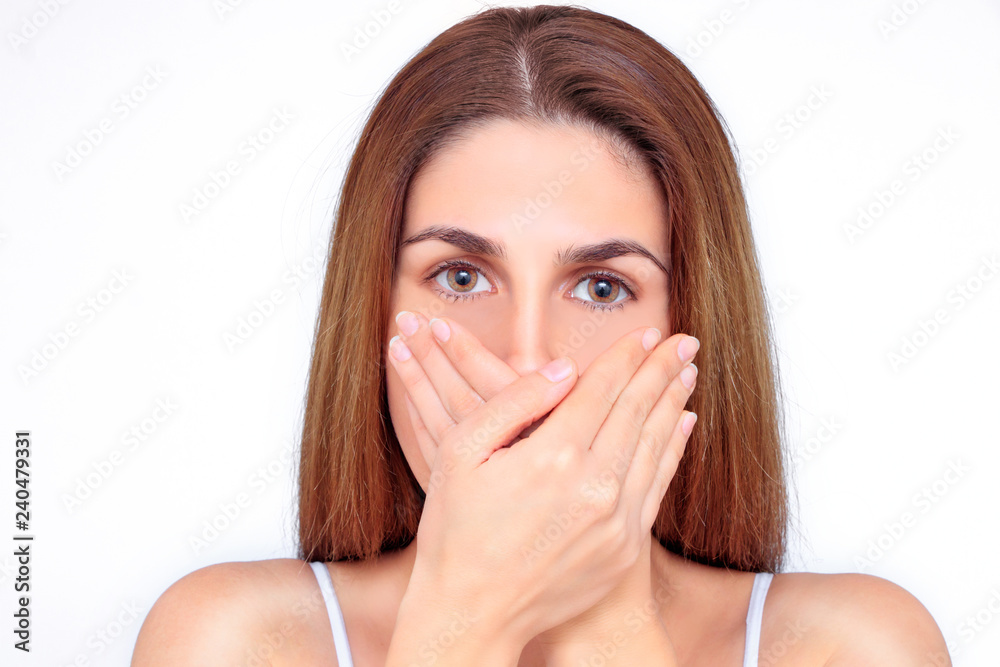 Beautiful woman closes her mouth with her hands Beautiful woman closes her mouth with her hands