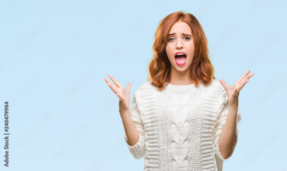 Young beautiful woman over isolated background wearing winter sweater celebrating crazy and amazed for success with arms raised and open eyes screaming excited. Winner concept Young beautiful woman over isolated background wearing winter sweater celebrating crazy and amazed for success with arms raised and open eyes screaming excited. Winner concept