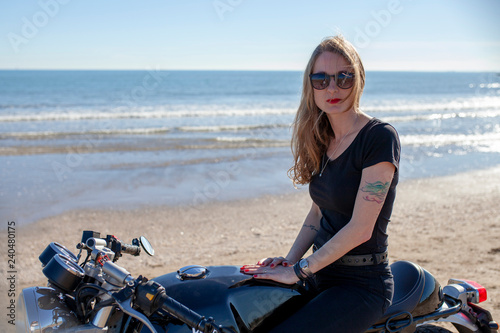 Mujer con motocicleta en la playa
