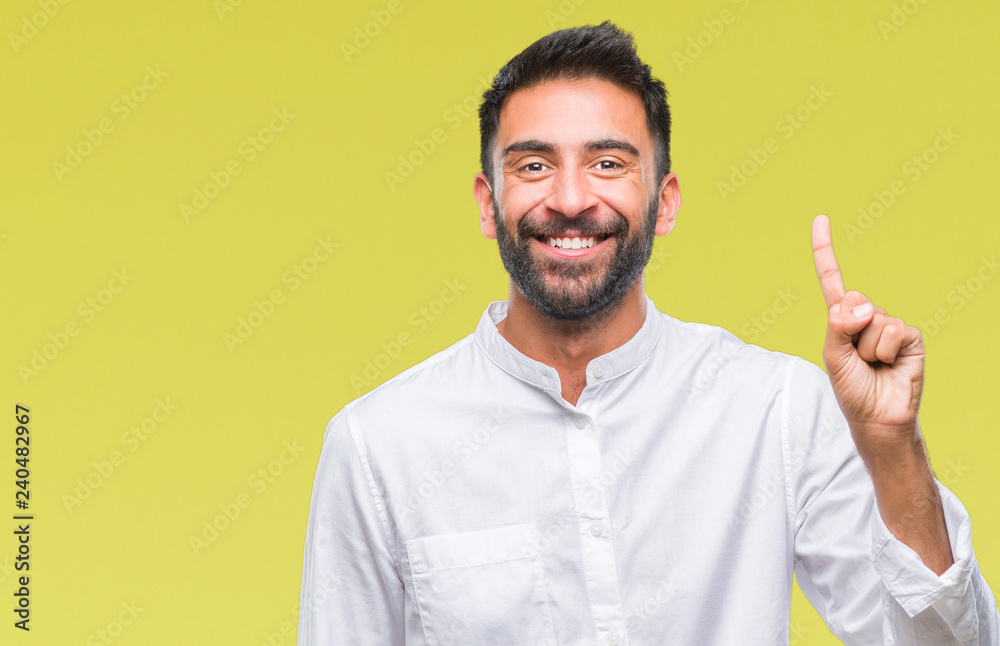 Adult hispanic man over isolated background showing and pointing up with finger number one while smiling confident and happy. Adult hispanic man over isolated background showing and pointing up with finger number one while smiling confident and happy.