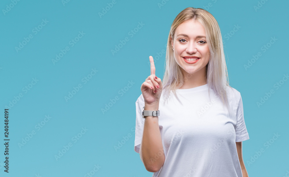 Young blonde woman over isolated background showing and pointing up with finger number one while smiling confident and happy. Young blonde woman over isolated background showing and pointing up with finger number one while smiling confident and happy.
