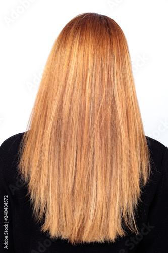 Long full blond hair of a woman from behind