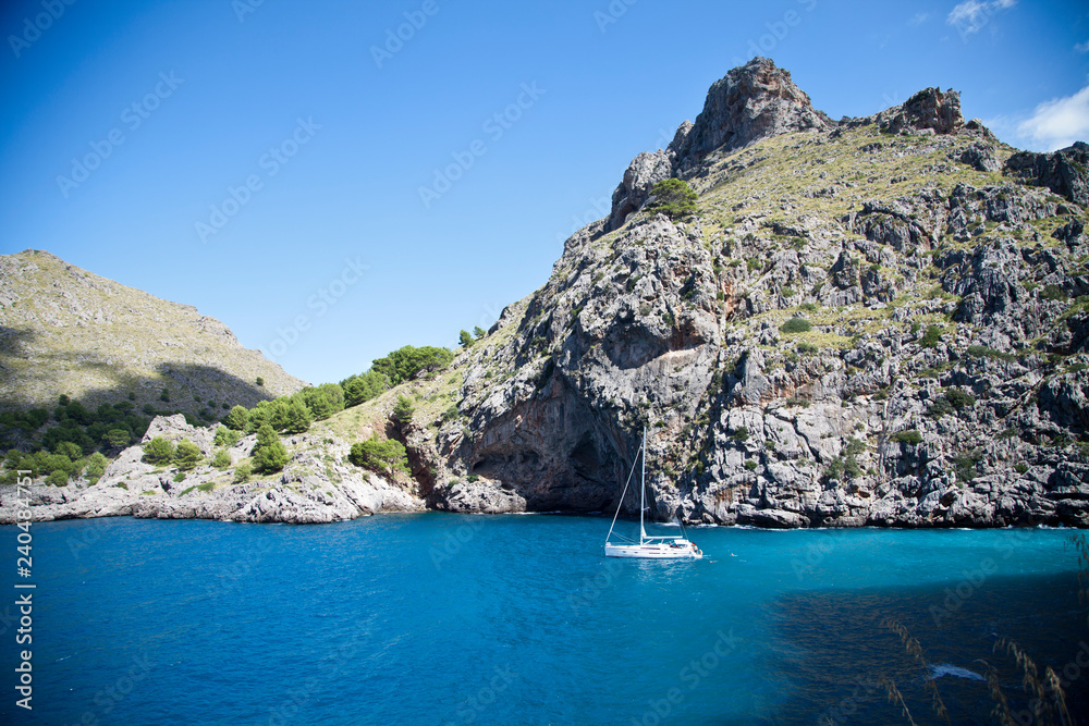 yacht on a background of blue clear water and rocks. the mediterranean