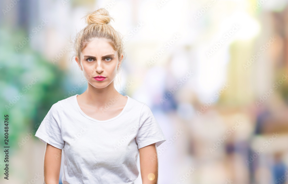 Young beautiful blonde woman wearing white t-shirt over isolated background skeptic and nervous, frowning upset because of problem. Negative person.