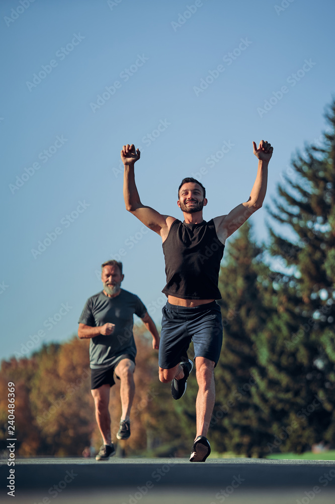 The two athletes running marathon in the beautiful park The two athletes running marathon in the beautiful park