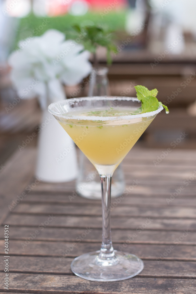  A cocktail  of Tequila, lime, mint leaves, and passionfruit