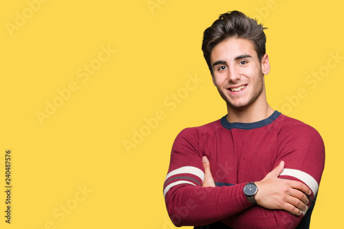 Young handsome man over isolated background happy face smiling with crossed arms looking at the camera. Positive person. © Krakenimages.com