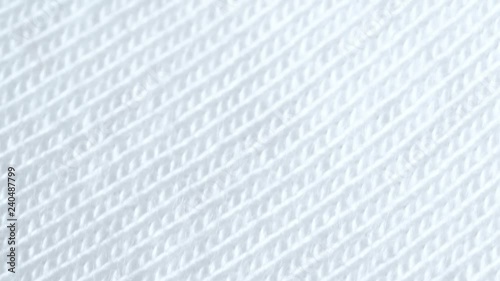 Textile background - white cotton lycra fabric with jersey (stockinette) structure. Weave pattern of threads close up.
