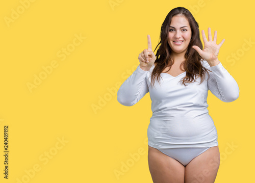 Beautiful plus size young overwight woman wearing white underwear over isolated background showing and pointing up with fingers number six while smiling confident and happy.