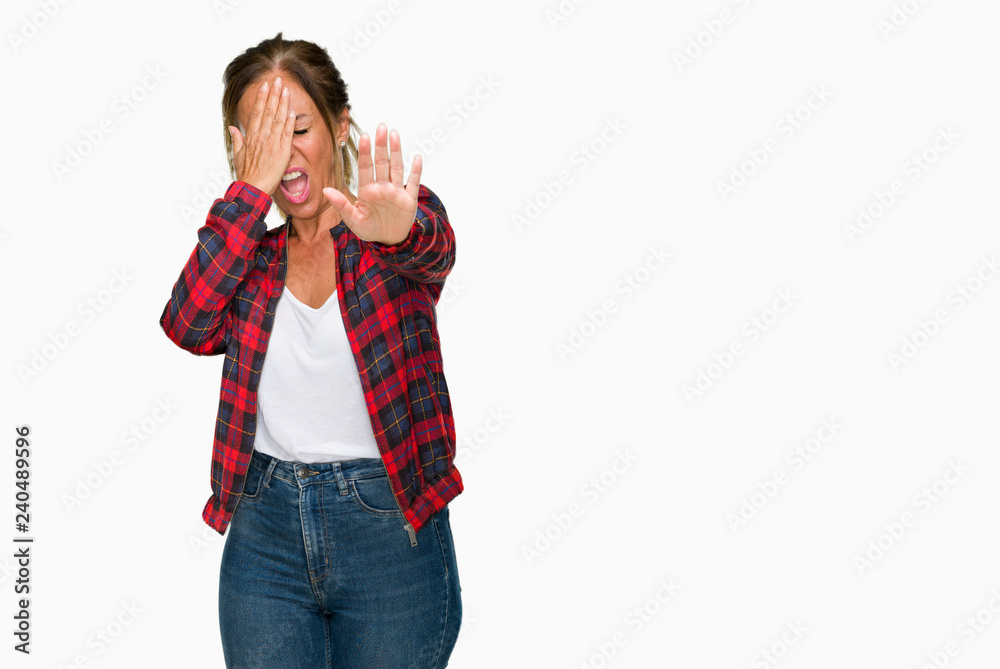 Middle age adult woman wearing casual jacket over isolated background covering eyes with hands and doing stop gesture with sad and fear expression. Embarrassed and negative concept. Middle age adult woman wearing casual jacket over isolated background covering eyes with hands and doing stop gesture with sad and fear expression. Embarrassed and negative concept.