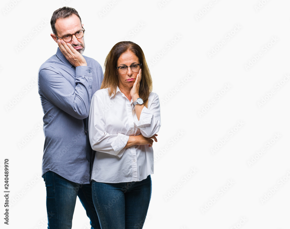 Middle age hispanic couple in love wearing glasses over isolated background thinking looking tired and bored with depression problems with crossed arms.