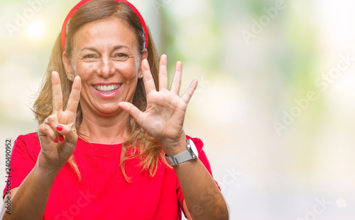 Middle age senior hispanic woman over isolated background showing and pointing up with fingers number seven while smiling confident and happy.