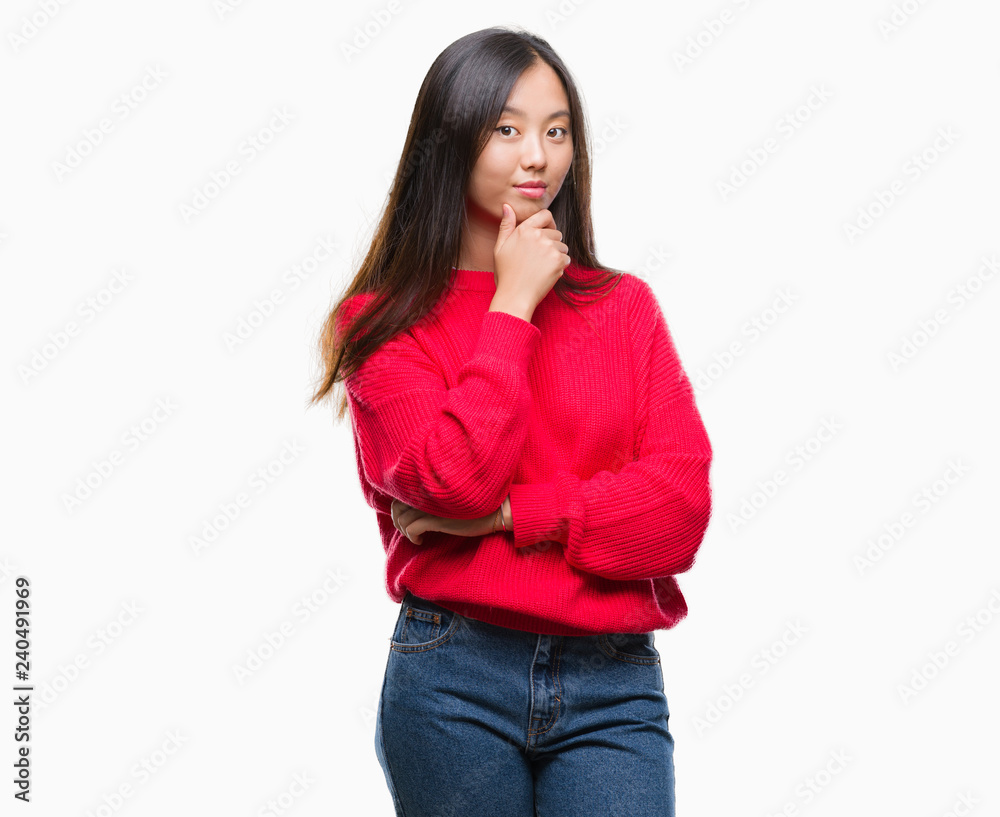 Young asian woman wearing winter sweater over isolated background looking confident at the camera with smile with crossed arms and hand raised on chin. Thinking positive.