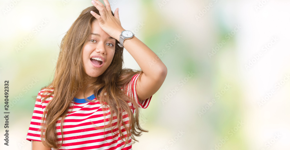 Young beautiful brunette woman wearing stripes t-shirt over isolated background surprised with hand on head for mistake, remember error. Forgot, bad memory concept. Young beautiful brunette woman wearing stripes t-shirt over isolated background surprised with hand on head for mistake, remember error. Forgot, bad memory concept.